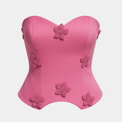 Pink strapless top with floral embellishments on a light gray background